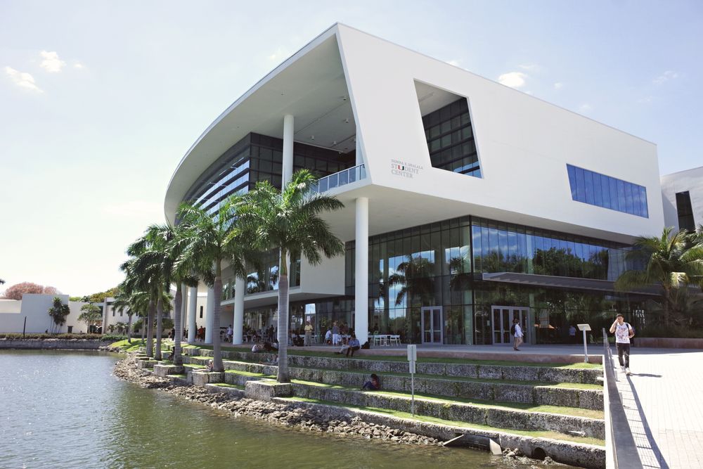 University architecture and palm trees beside a lake